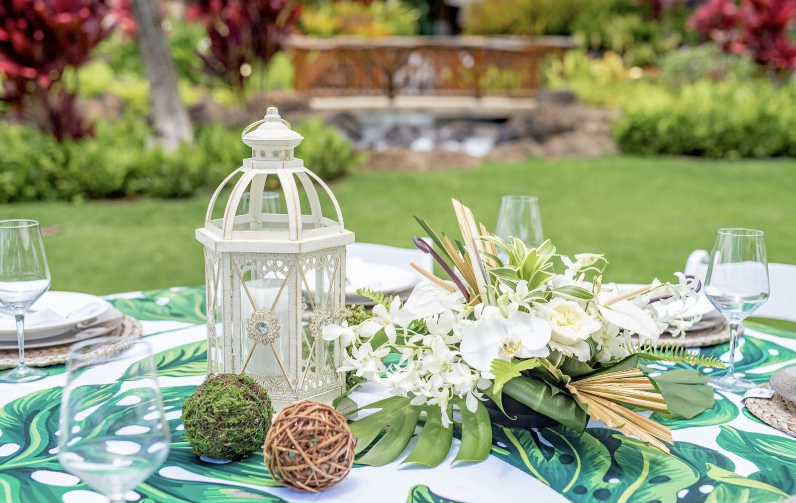 Outdoor dining table set with white flowers and lanterns in the resort gardens